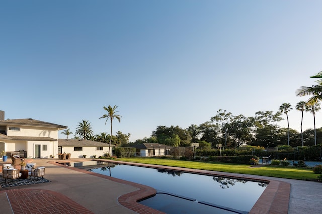 view of swimming pool featuring a yard and a patio