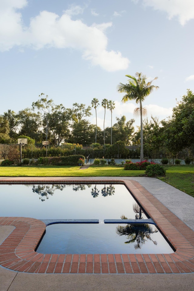 view of swimming pool with a yard