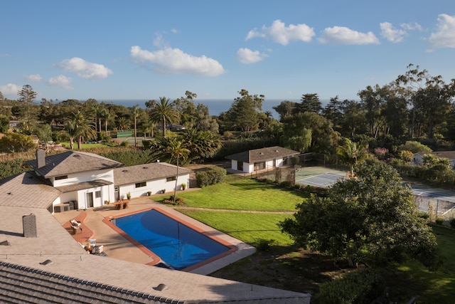 view of pool with tennis court, a lawn, and a patio area