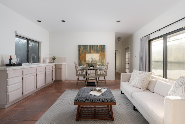 living room featuring sink and light tile patterned floors