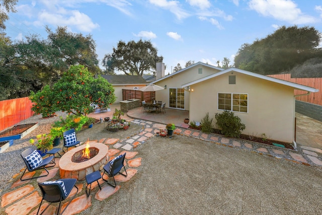 back of house with a patio area and a fire pit