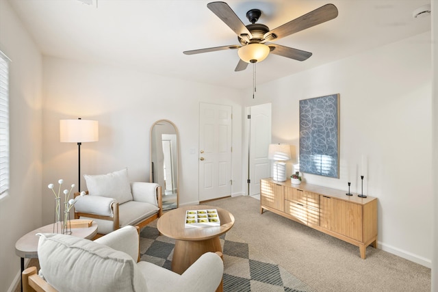 carpeted living room with ceiling fan