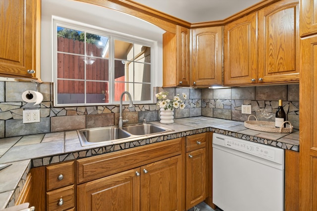 kitchen featuring sink, tile countertops, white dishwasher, and decorative backsplash