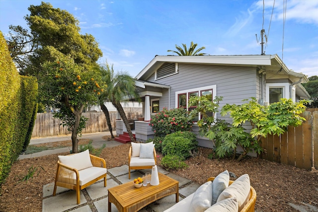 back of property with an outdoor living space and a patio