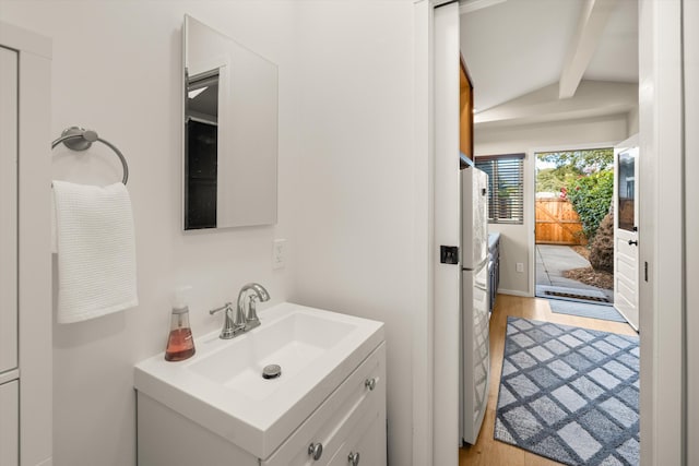 bathroom featuring vaulted ceiling with beams, wood finished floors, and vanity