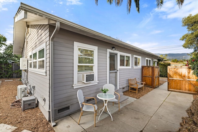 rear view of house with a patio, cooling unit, a mountain view, fence, and crawl space