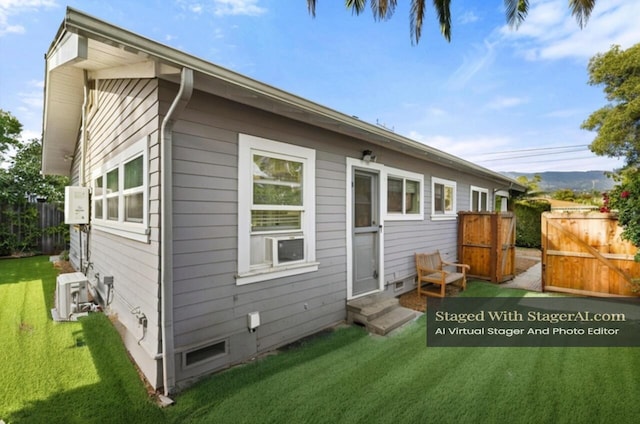 rear view of property featuring entry steps, crawl space, a lawn, and fence