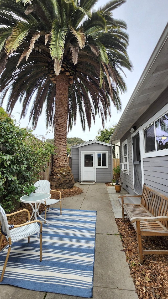 view of patio with an outdoor structure and fence