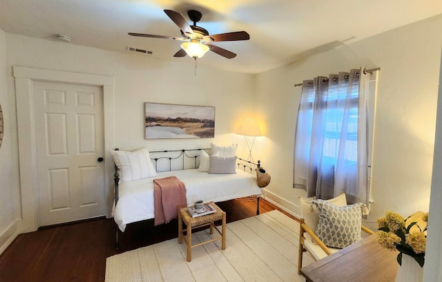 bedroom featuring a ceiling fan, baseboards, visible vents, and wood finished floors