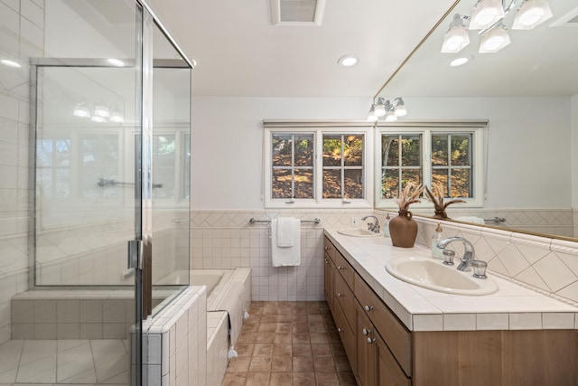 bathroom with plus walk in shower, tile walls, and vanity