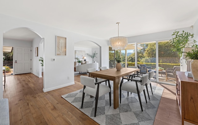 dining area featuring an inviting chandelier and light hardwood / wood-style floors