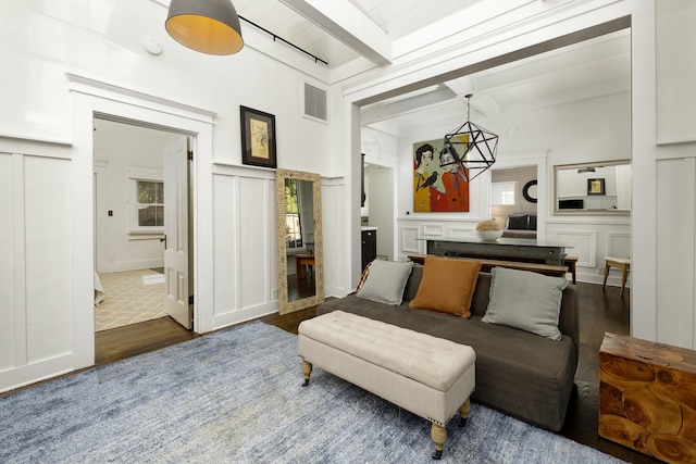 bedroom with beamed ceiling, connected bathroom, and dark hardwood / wood-style flooring