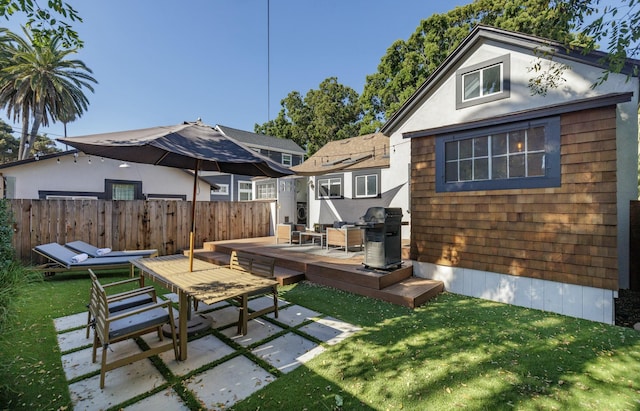 rear view of property featuring a yard, a patio, and a deck