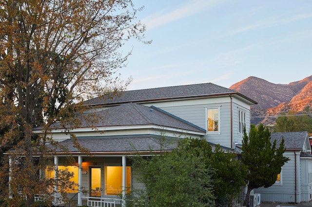 view of side of property featuring a mountain view and covered porch