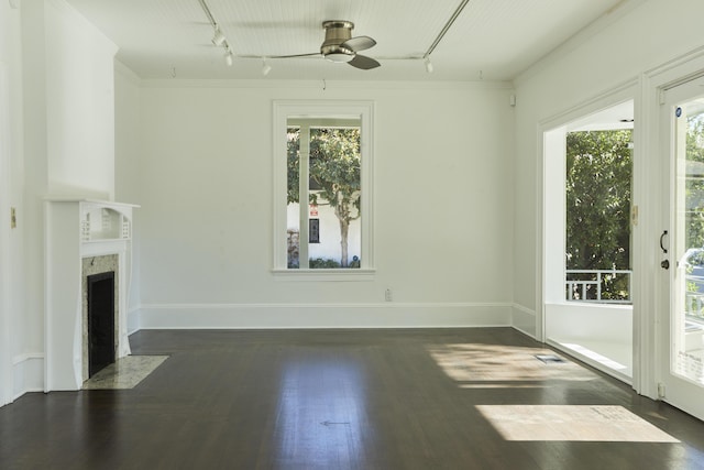 unfurnished living room with ornamental molding, plenty of natural light, dark wood-type flooring, and a fireplace