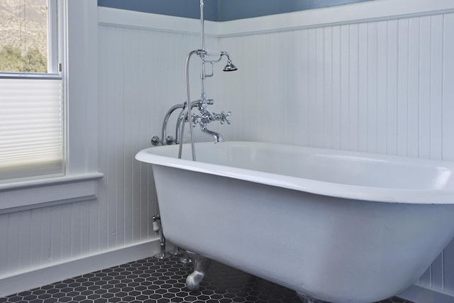 bathroom with tile patterned flooring and a washtub