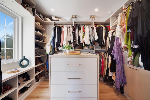 walk in closet with light hardwood / wood-style floors