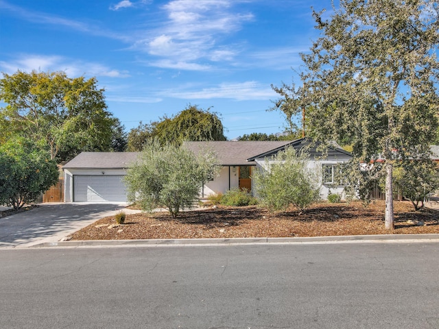 view of property hidden behind natural elements with a garage