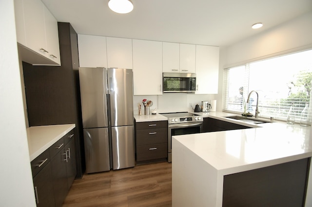 kitchen featuring sink, dark wood-type flooring, stainless steel appliances, and white cabinets