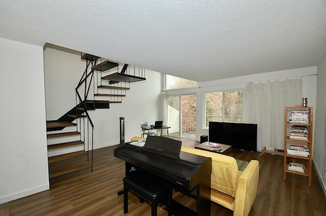 dining space featuring dark wood-type flooring and a textured ceiling