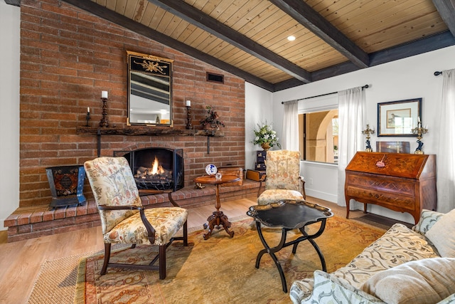 living room with hardwood / wood-style flooring, wood ceiling, a fireplace, and vaulted ceiling with beams