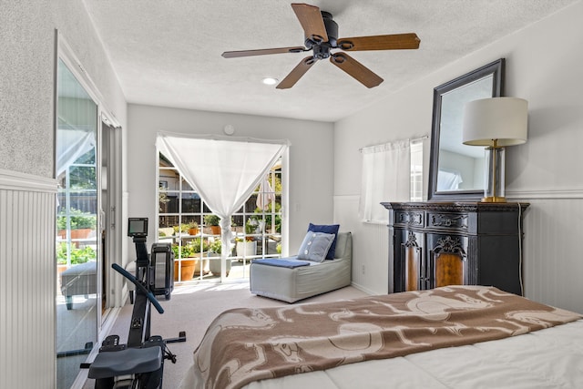 carpeted bedroom with access to exterior and a textured ceiling