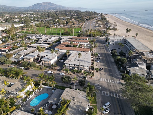 drone / aerial view with a beach view and a water and mountain view