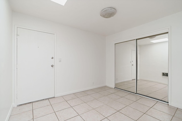 unfurnished bedroom featuring light tile patterned floors and a closet