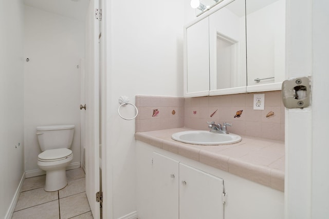 bathroom with tile patterned flooring, vanity, tasteful backsplash, and toilet