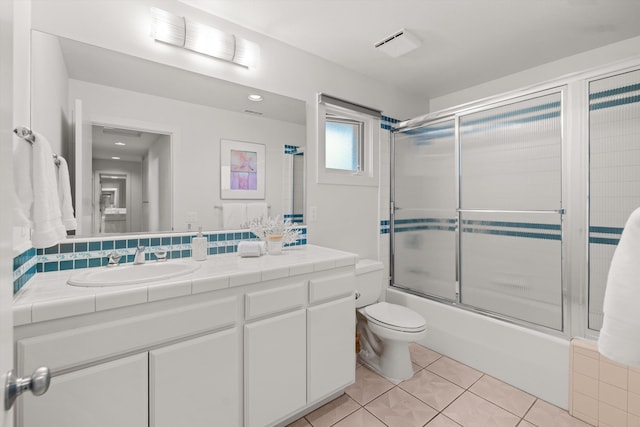 full bathroom with tile patterned flooring, vanity, toilet, and combined bath / shower with glass door