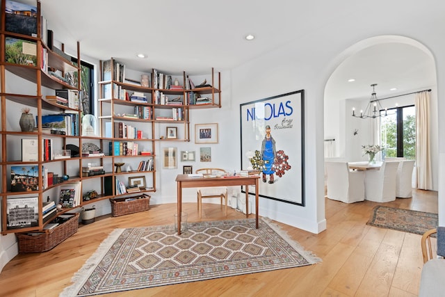 office space featuring an inviting chandelier and wood-type flooring