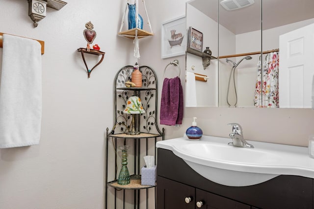 bathroom featuring walk in shower and vanity