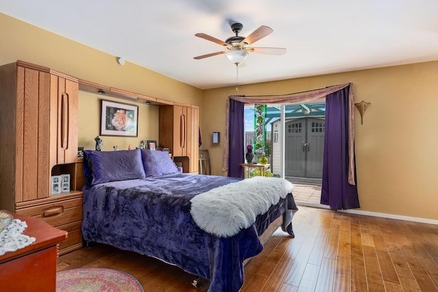 bedroom with hardwood / wood-style flooring, access to outside, and ceiling fan