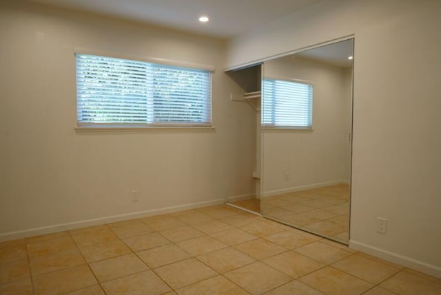 unfurnished bedroom featuring a closet and light tile patterned floors