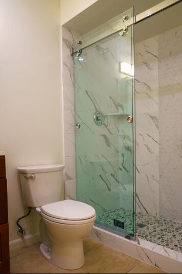 bathroom featuring tile patterned flooring, vanity, toilet, and walk in shower