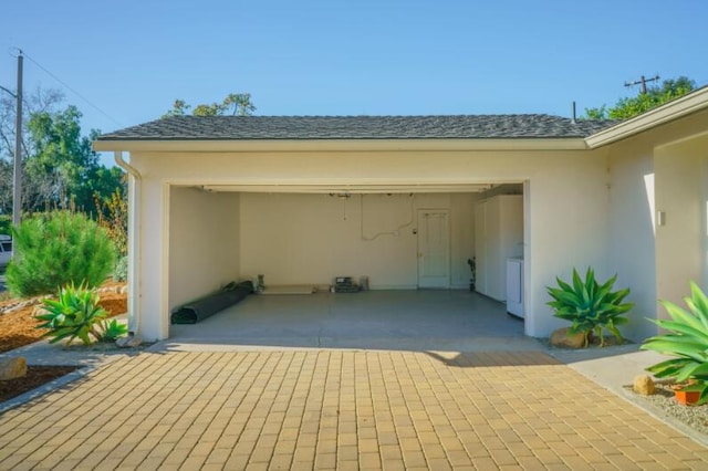 view of vehicle parking featuring a garage and washer / dryer