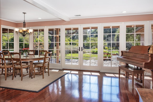 interior space featuring beamed ceiling, ornamental molding, dark wood-type flooring, and an inviting chandelier