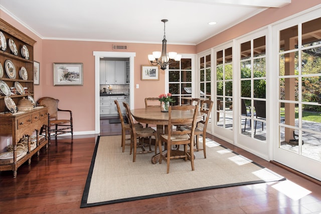 dining space with ornamental molding, dark hardwood / wood-style floors, and a chandelier