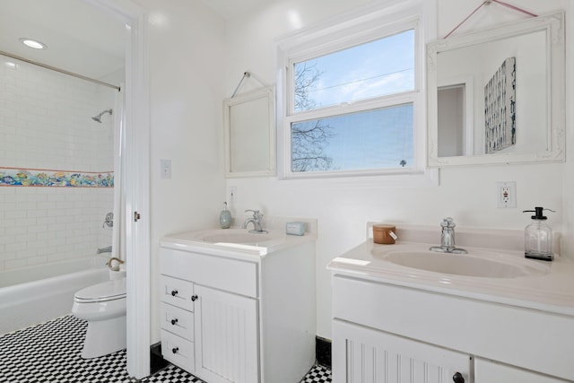 full bathroom with vanity, tiled shower / bath, and toilet