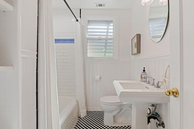 bathroom with toilet and shower / bath combo with shower curtain