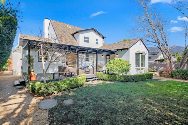 back of house with a pergola, a yard, and an outdoor hangout area