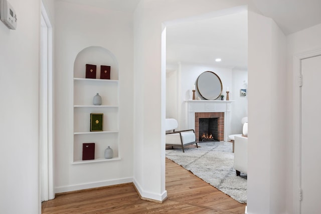 hallway featuring hardwood / wood-style floors and built in features