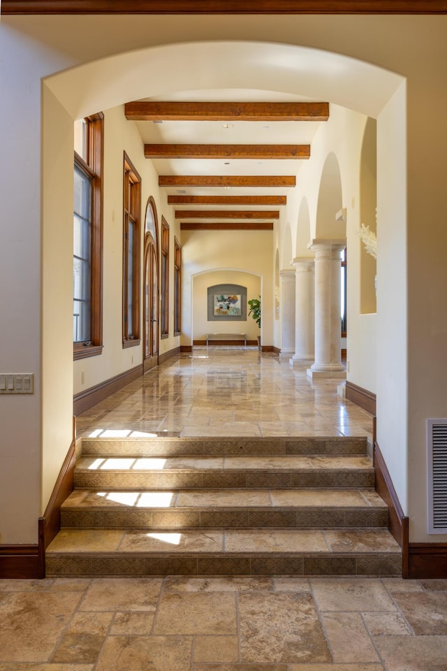 interior space with beamed ceiling and ornate columns