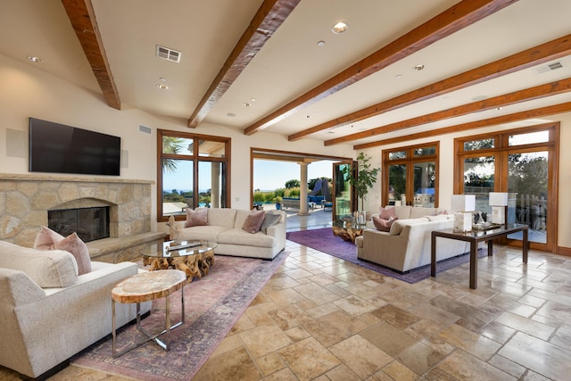 living room with french doors, a stone fireplace, and beam ceiling