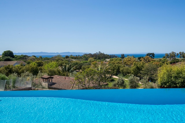 view of pool featuring a water view