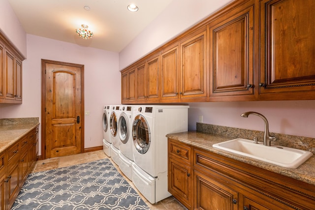 laundry room with sink, light tile patterned floors, cabinets, and washer and dryer