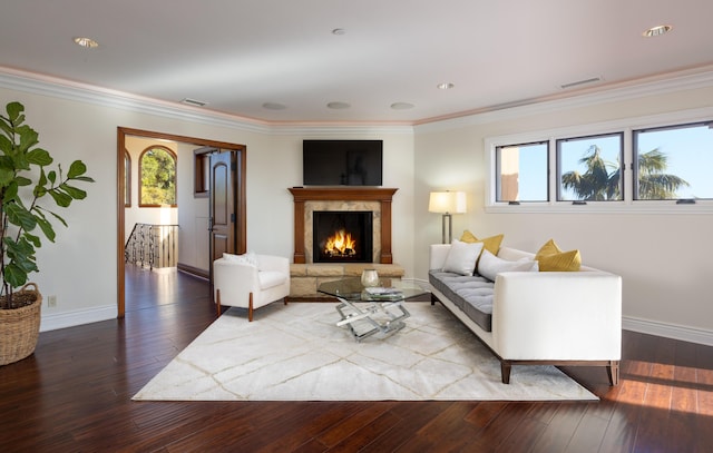 living room with crown molding, wood-type flooring, and a premium fireplace