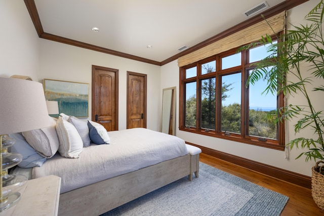 bedroom featuring wood-type flooring and ornamental molding