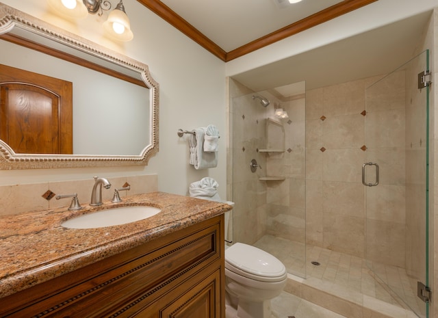 bathroom with crown molding, vanity, toilet, and a shower with shower door