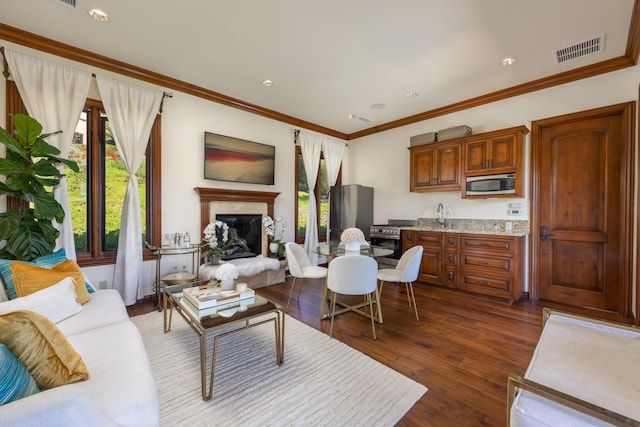 living room with crown molding, dark wood-type flooring, wet bar, and a high end fireplace